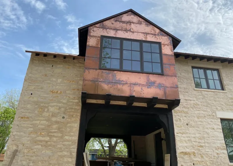 Copper metal panel facade on a stone building for Roof Repair in Sturgis